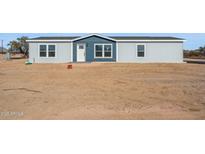 Single-story home with blue and gray exterior, and a spacious yard at 53212 W Barn Owl Rd, Maricopa, AZ 85139