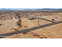 Aerial view of a single-story home on a large lot with mountain views at 53259 W Barn Owl Rd, Maricopa, AZ 85139