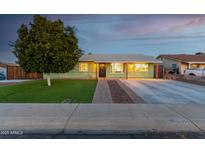 Charming light green single story home with landscaped yard and driveway at 10395 N 73Rd Dr, Peoria, AZ 85345