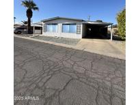 Single-wide mobile home with carport and mature palm tree at 120 N Val Vista Dr # 38, Mesa, AZ 85213