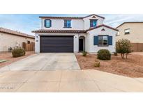 Charming two-story home featuring a two car garage, desert landscaping, and a classic stucco facade at 40445 W Bravo Dr, Maricopa, AZ 85138