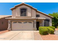 Two-story house with a beige exterior, two-car garage, and landscaping at 62 W Melody Dr, Gilbert, AZ 85233