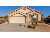 Tan one-story house with two-car garage and desert landscaping at 14529 N 87Th Dr, Peoria, AZ 85381