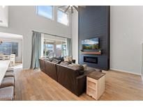 Spacious living room featuring a modern fireplace and high ceilings at 23059 E Pummelos Rd, Queen Creek, AZ 85142