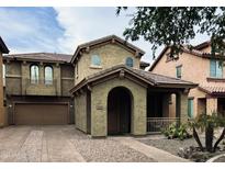 Two-story house with brown exterior, two-car garage, and landscaped front yard at 3948 E Morelos St, Gilbert, AZ 85295