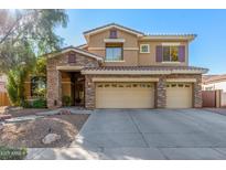 Two-story house with stone accents and a three-car garage at 4221 E Carriage Way, Gilbert, AZ 85297