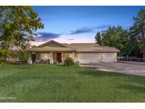 Single-story home with three-car garage and large front yard at 6841 N 183Rd Ave, Waddell, AZ 85355