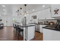 Modern kitchen with white cabinets, large island, and stainless steel appliances at 7715 E Catalina Dr, Scottsdale, AZ 85251