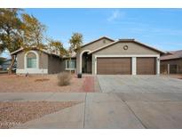 Single-story home with a three-car garage and desert landscaping at 7818 W Encinas Ln, Phoenix, AZ 85043