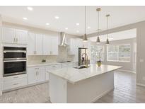 Modern kitchen with white cabinets, quartz countertops, and island at 7818 W Encinas Ln, Phoenix, AZ 85043