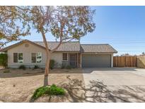 Single-story house with gray garage door and mature tree in front at 7915 W Wethersfield Rd, Peoria, AZ 85381