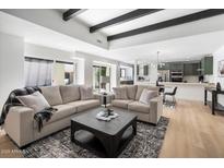 Bright living room featuring vaulted ceilings, dark wood beams, neutral paint, and an open floor plan at 8013 N 73Rd St, Scottsdale, AZ 85258