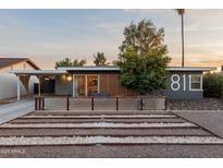 Charming home featuring desert landscaping and a cozy front patio with wood slat privacy screen at 811 W Whitton Ave, Phoenix, AZ 85013