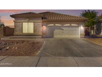 Single-story home with attached garage and landscaped front yard at 15548 N 156Th Ln, Surprise, AZ 85374