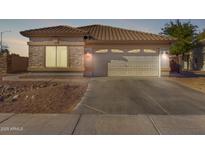 Single-story home with a two-car garage and desert landscaping at 15548 N 156Th Ln, Surprise, AZ 85374