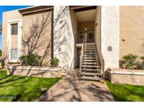 Exterior view of condo building with stairs leading to entrance and landscaping at 2146 W Isabella Ave # 252, Mesa, AZ 85202