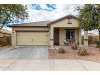 Single-story home with tan exterior, two-car garage, and covered porch at 4908 S 244Th Ave, Buckeye, AZ 85326