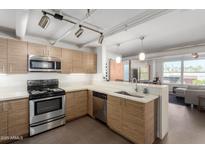 Modern kitchen with stainless steel appliances and wood cabinets at 535 W Thomas Rd # 213, Phoenix, AZ 85013