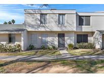 Two-story condo with light-colored siding, a walkway, and landscaping at 6415 S El Camino Dr, Tempe, AZ 85283