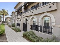 Front view of a modern townhouse with a gated entry and paved walkway at 6565 E Thomas Rd # 1141, Scottsdale, AZ 85251