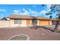 One-story house with a large orange garage door and a well-maintained front yard at 6730 W Vernon Ave, Phoenix, AZ 85035