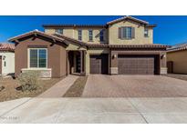 Two-story house with brown and beige exterior, large windows, and a three-car garage at 7214 W Buckhorn Trl, Peoria, AZ 85383