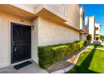 Exterior view of condo with a well-manicured lawn and a security door at 7910 E Thomas Rd # 118, Scottsdale, AZ 85251