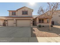 Two-story house with a three-car garage and desert landscaping at 10325 W Windsor Ave, Avondale, AZ 85392