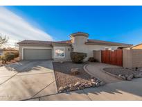 Single-story home with desert landscaping and a gated courtyard entry at 14836 W Desert Hills Dr, Surprise, AZ 85379