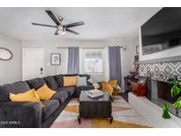 Bright living room with sectional sofa, fireplace, and large TV at 2605 W Montebello Ave, Phoenix, AZ 85017