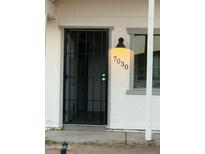 Front entrance of the house, featuring a security gate and exterior light at 7030 W Cypress St, Phoenix, AZ 85035