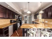 Modern kitchen with dark wood cabinets and granite counters at 102 W El Caminito Dr, Phoenix, AZ 85021