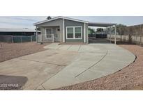 Single-wide manufactured home with carport and paved driveway at 318 S Ellsworth Rd, Mesa, AZ 85208