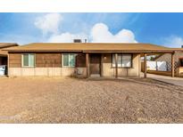 Ranch style home with a covered entry and spacious front yard at 5932 W Holly St, Phoenix, AZ 85035