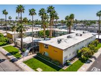 Aerial view of a mid-century modern apartment building with a pool and lush landscaping at 6805 E 2Nd St # 17, Scottsdale, AZ 85251