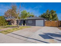 Cute bungalow with gray exterior, white garage door, and a brick walkway at 12023 N 113Th Ave, Youngtown, AZ 85363
