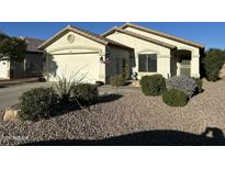 Charming single-story home with well-maintained landscaping and an attached two-car garage at 14767 N 148Th Ave, Surprise, AZ 85379