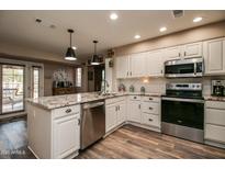 Updated kitchen featuring granite countertops, white cabinetry, and stainless steel appliances at 17826 N Buntline Dr, Sun City West, AZ 85375