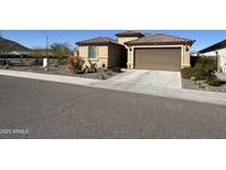 Charming single Gathering home featuring a tan exterior, brown garage door and low maintenance desert landscaping at 6516 W Madre Del Oro Dr, Phoenix, AZ 85083