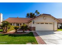 Single-story home with a two-car garage and nicely landscaped front yard at 19037 N 73Rd Ln, Glendale, AZ 85308