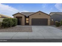 Single-story home with a two-car garage and desert landscaping at 20249 W Woodlands Ave, Buckeye, AZ 85326