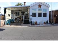 Mobile home exterior features a covered patio and well-maintained landscaping at 306 S Recker Rd # 267, Mesa, AZ 85206