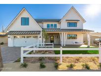 Two-story farmhouse features white siding, a metal roof, and a white picket fence at 3427 E Campbell Ave, Phoenix, AZ 85018