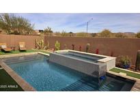 Stunning backyard pool and spa featuring a tiled wall, desert landscaping, and ample space for relaxation at 40715 N Lytham Ct, Anthem, AZ 85086