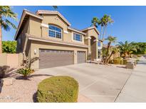 Two-story house with three-car garage and landscaped front yard at 13002 W Llano Dr, Litchfield Park, AZ 85340
