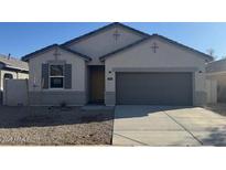 Charming single-story home with gray trim, neutral colored stucco and a two-car garage at 1419 W Hess Ave, Coolidge, AZ 85128