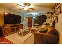 Cozy living room featuring a sectional sofa, large TV, and wood-look floors at 17241 N 16Th Dr # 10, Phoenix, AZ 85023