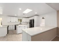 Modern kitchen with white cabinets, large island, and stainless steel appliances at 17642 N Whispering Oaks Dr, Sun City West, AZ 85375