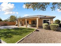 Back of house with solar panels, covered patio, and landscaped yard at 20089 N 263Rd Dr, Buckeye, AZ 85396