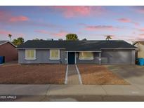 Gray house with a blue door, walkway, and landscaping at 3926 E Captain Dreyfus Ave, Phoenix, AZ 85032